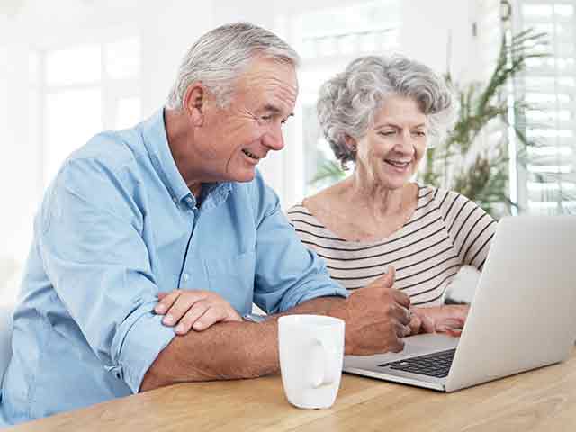image of a senior couple using a laptop at home